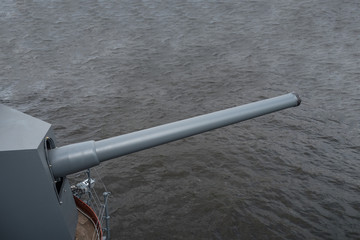 Naval gun. Gun on the gray water background.