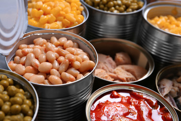 Open tin cans with conserved products, closeup