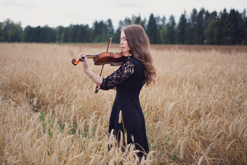 a beautiful young woman playing the violin closed her eyes with pleasure. violinist © Denis Ivanov