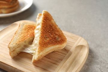 Wooden board with fresh cheese sandwiches on table