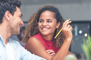 Young businessman and businesswoman in casual clothes having a new project discussion or having an idea at workplace.