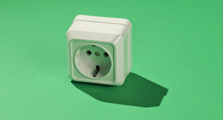 White plastic power socket on green background. Minimalism