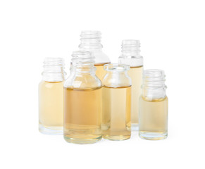 Glass bottles of essential oils on white background