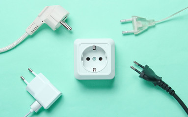 The concept of electrical dependence. Lots of power plugs near power outlets on blue background