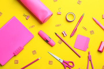 Pink school stationery on yellow background, flat lay