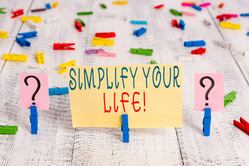 Writing note showing Simplify Your Life. Business concept for focused on important and let someone else worry about less ones Crumbling sheet with paper clips placed on the wooden table