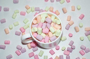A cup of coffee with colorful marshmallows in a white mug.