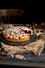 homemade tasty biscuit cake with cherries, almond flakes, powdered sugar on top