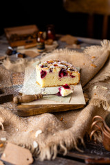 homemade tasty biscuit cake with cherries, almond flakes, powdered sugar on top