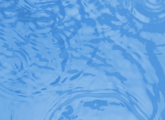 Concentric waves on blue water surface after falling drops, top view