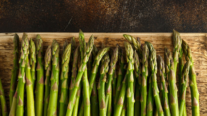 Freshly picked organic asparagus tips on wooden board