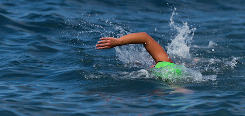 Arm of a swimmer athlete swimming in the ocean, competition swimming at triathlon