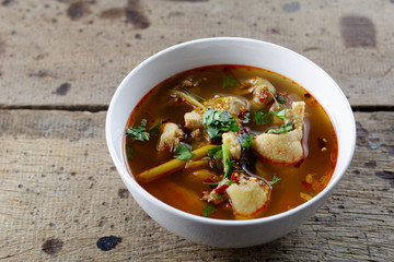 Tom Yum Gai ban,spicy and sour chicken soup on wooden table