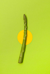 Fresh raw asparagus on green table background.