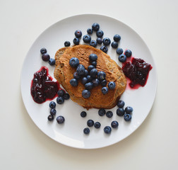 Top view of pancakes with blueberries and jam