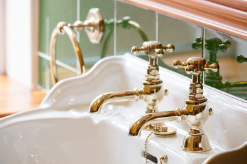 New luxury hotel vintage brass gold plated pillar taps in ensuite bathroom at wash basin