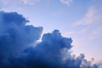 Thunderclouds are approaching the clear blue sky, copy space. The clouds are dark blue and the evening sky is clear. Weather before coming storm.
