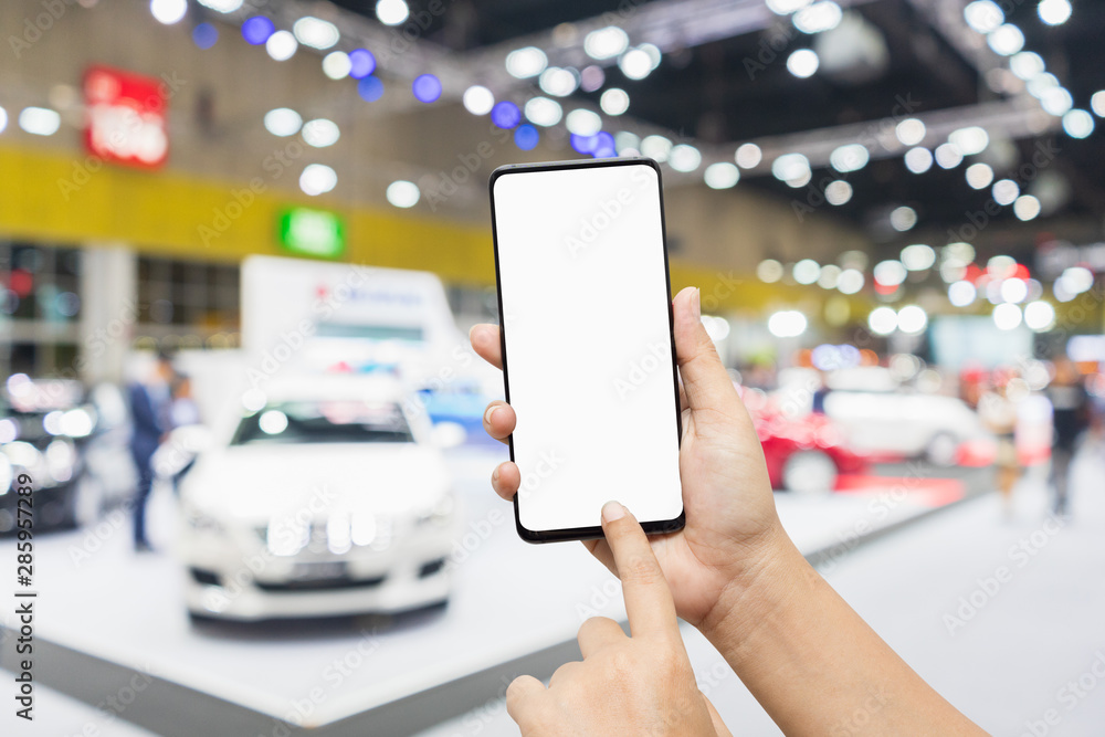 Poster mock up mobile phone. hand holding smartphone with abstract blurred defocused image of public event 