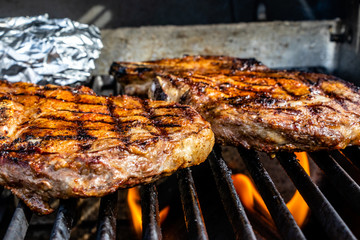 Fire licking the steaks on the grill. Calgary, Alberta, Canada