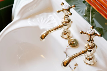 New luxury hotel vintage brass gold plated pillar taps in ensuite bathroom at wash basin