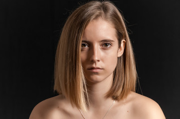 Fototapeta premium Blonde girl photographed in studio with black background.