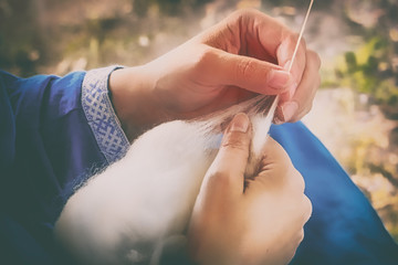 Creating yarn threads, close-up. Distaff in nature, rustic style