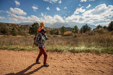 A man with his son are hiking in mountains