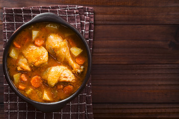 Fresh homemade chicken stew with potato, carrot and celery, seasoned with paprika in rustic bowl,...