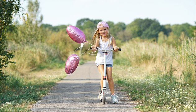 lachendes M&auml;dchen mit ihrem Roller