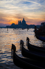 Beautiful sunset over Venice Lagoon with gondola characteristic iron bows