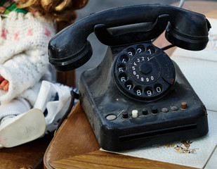 Old dirty dusty analog black phone with mechanical dial