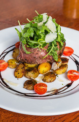 Grilled steak with fresh tomatoes and garlics.