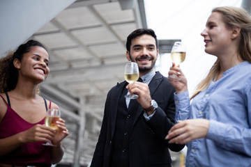 Group of business people celebrate by drinking wine.