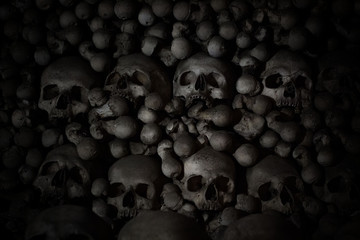 Numerous creepy skulls in the dark. Abstract concept symbolizing death, terror, and evil.