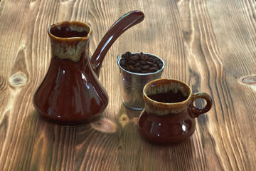 cup with cezve on a wooden table