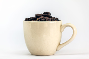 White cup of coffee and coffee grains surrounded