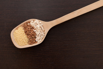 oatmeal, millet, buckwheat in a wooden spoon close-up on the table