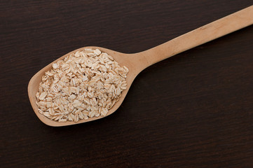 oatmeal in a wooden spoon on a wooden table