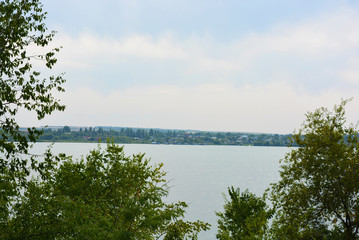Beautiful view of the Samara River with picturesque steep banks and coast, trees, greenery and rich sky. Bright and unforgettable nature in the housing estate, Shevchenko, Dnipro, Ukraine.