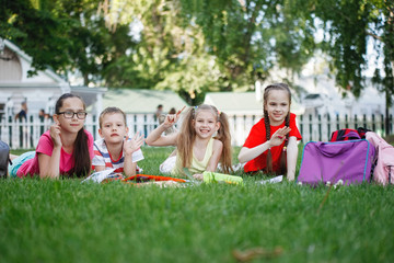 Four children sitting on the green grass.