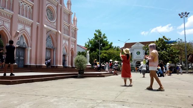Tourist walking around and taking photos of a church in Da Nang, Time Lapse Pan