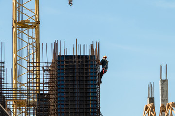 The builder rises to the top of the building under construction.