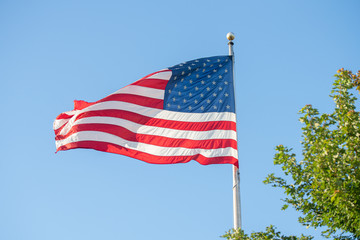 American flag flies high overhead in the strong winds