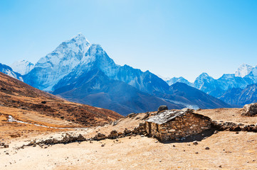 Stone house in the mountains and view of Mount Ama Dablam in Himalayas, Nepal. Khumbu valley, Everest region