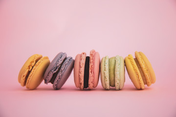 Assortment of French macarons on pink background