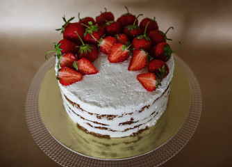 the beautiful cake with strawberries and cream on table