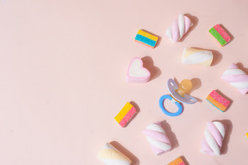 Pastel cute background with pacifier and sweets top view flat lay