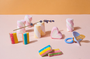 Cute pastel pink composition with marshmallow and candies