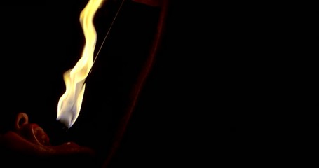 fire show. a man swallows a burning torch in his mouth and extinguishes it there in the dark
