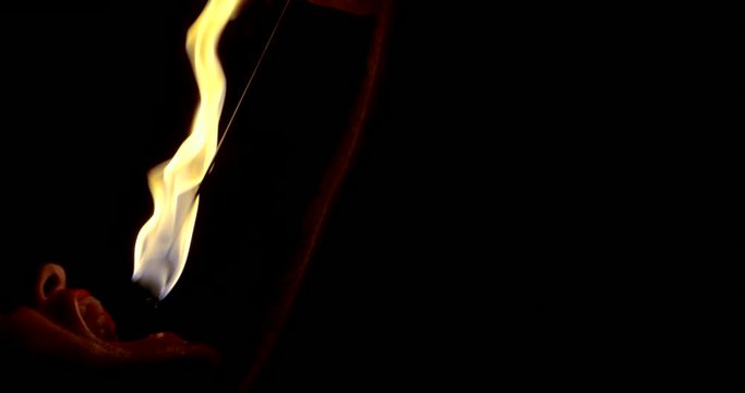 fire show. a man swallows a burning torch in his mouth and extinguishes it there in the dark